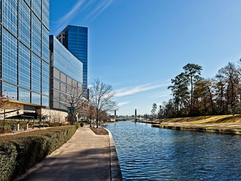 A Lake next to buildings in The Woodlands, TX